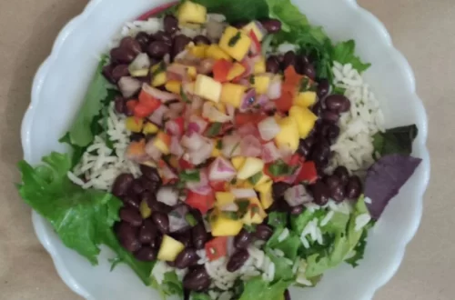Zesty Mango, Black Bean, and Rice Salad with fresh greens, black beans, cooked rice, and mango salsa.