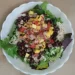 Zesty Mango, Black Bean, and Rice Salad with fresh greens, black beans, cooked rice, and mango salsa.