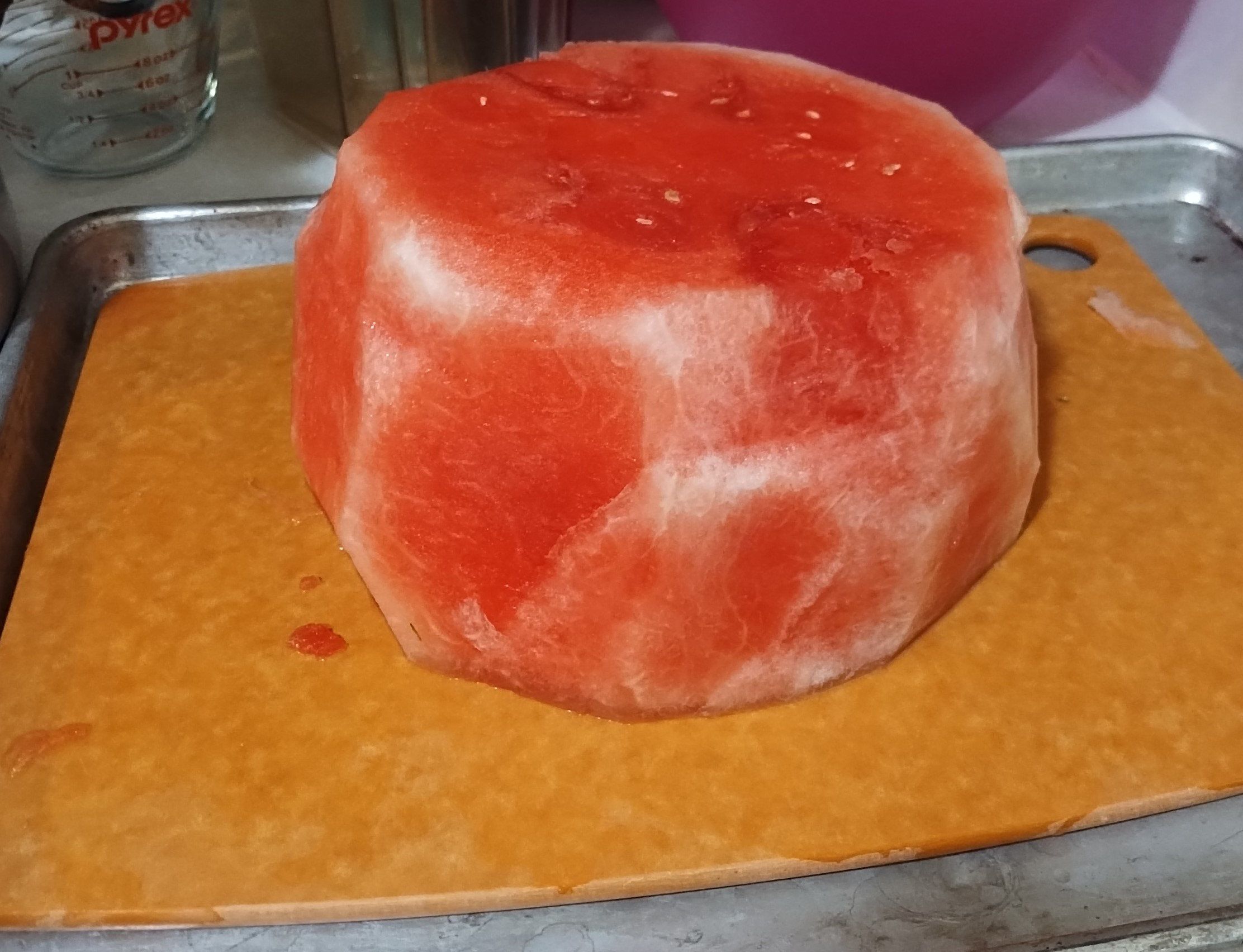 Watermelon on cutting board on baking pan